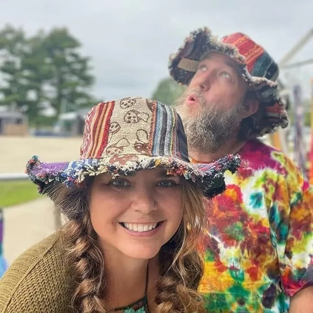 Two people wearing colorful hats with a blurred outdoor background